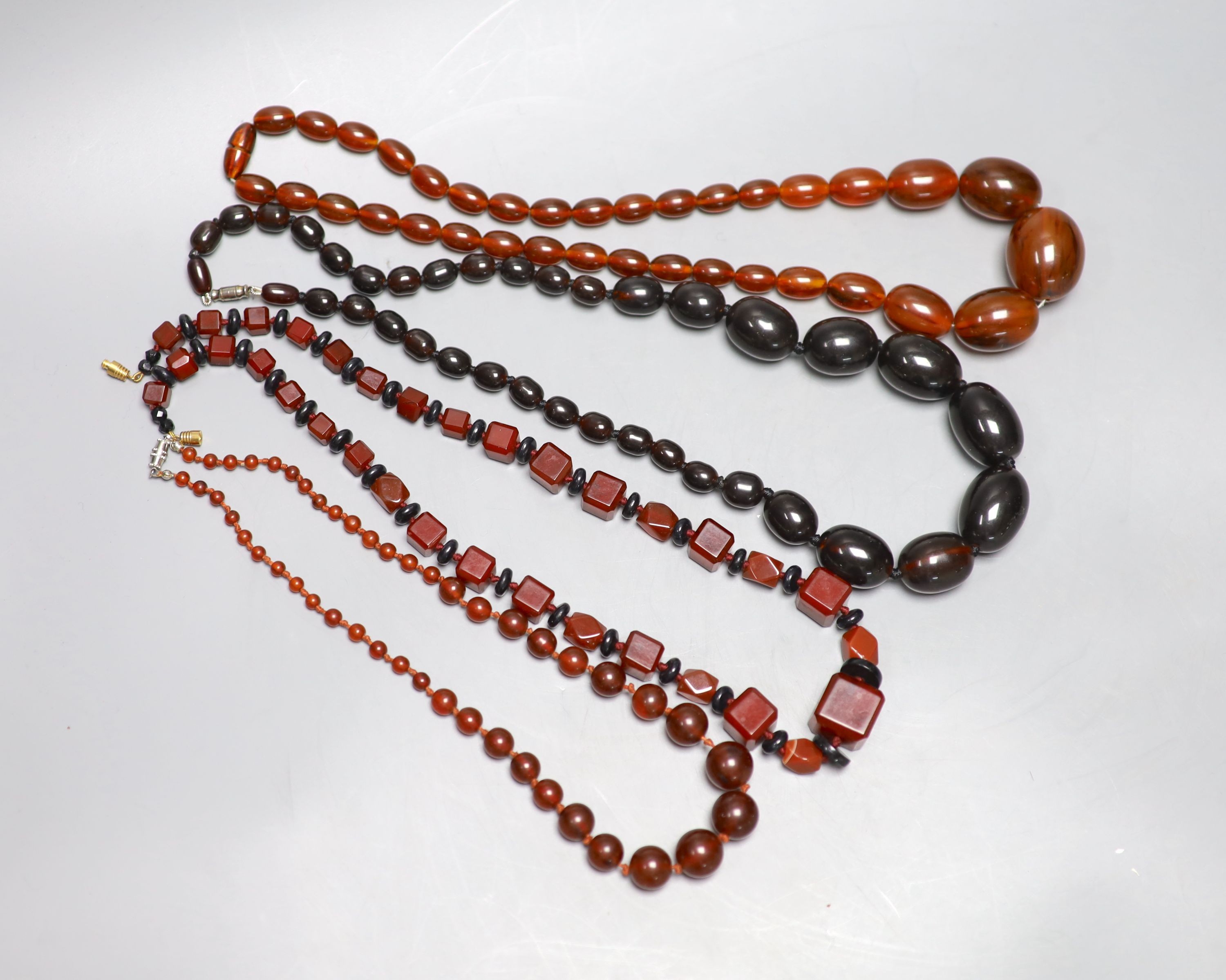 Four assorted simulated amber bead necklaces, largest 62cm.